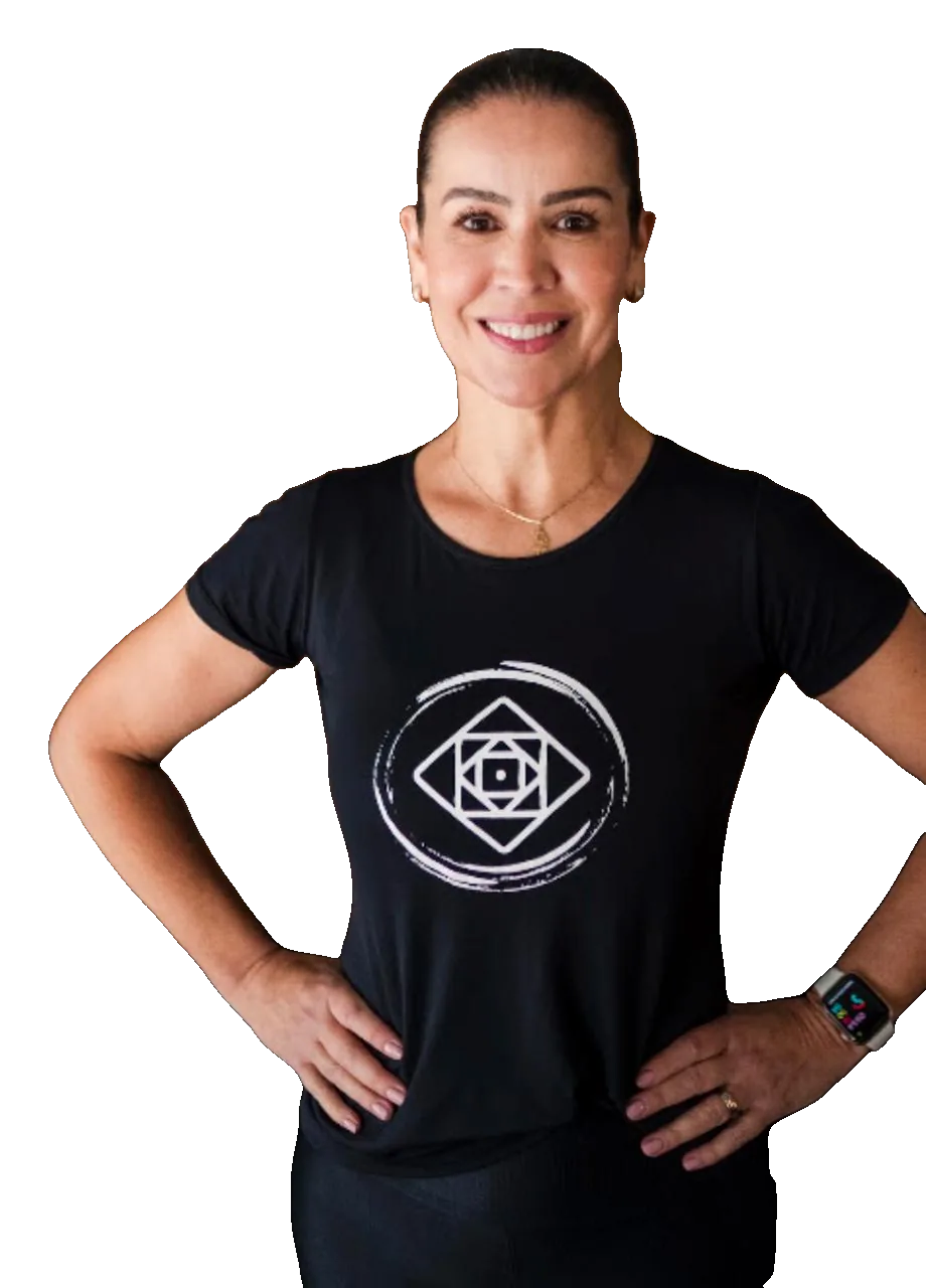 Andrea, de camiseta preta do Studio Pawo, com as mãos na cintura