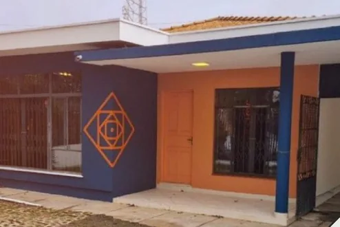 Fachada da unidade Água Verde, uma casa térrea azul e laranja com o símbolo da marca